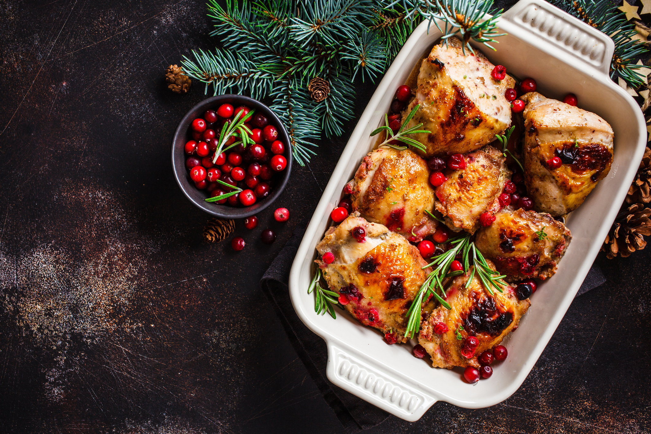 Christmas food. Baked Chicken meat with cranberries and rosemary in the oven dish, dark background, copy space. Christmas food. Baked Chicken meat with cranberries and rosemary in the oven dish, dark background, copy space.