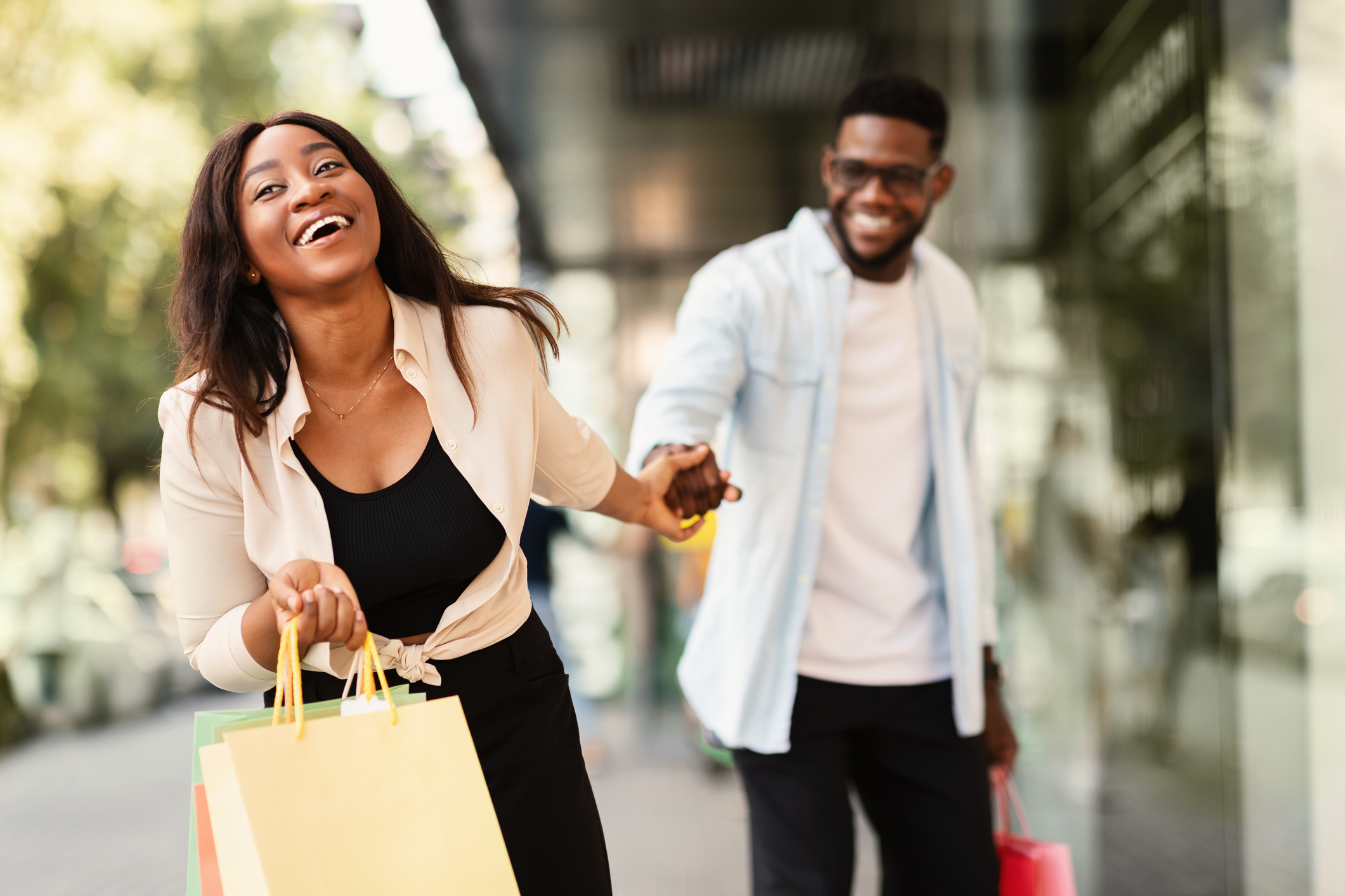 Excited Black Woman Pulling Boyfriend To Shopping Store