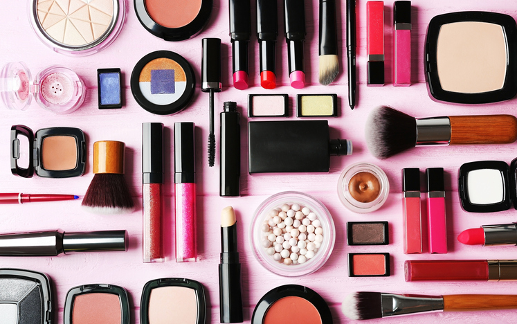 Flat lay of makeup cosmetics on pink background