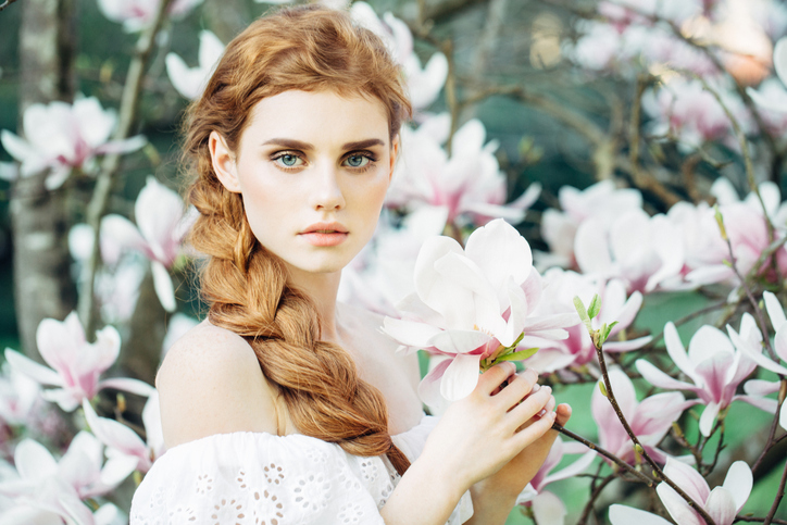 Beautiful girl on the background of spring bush