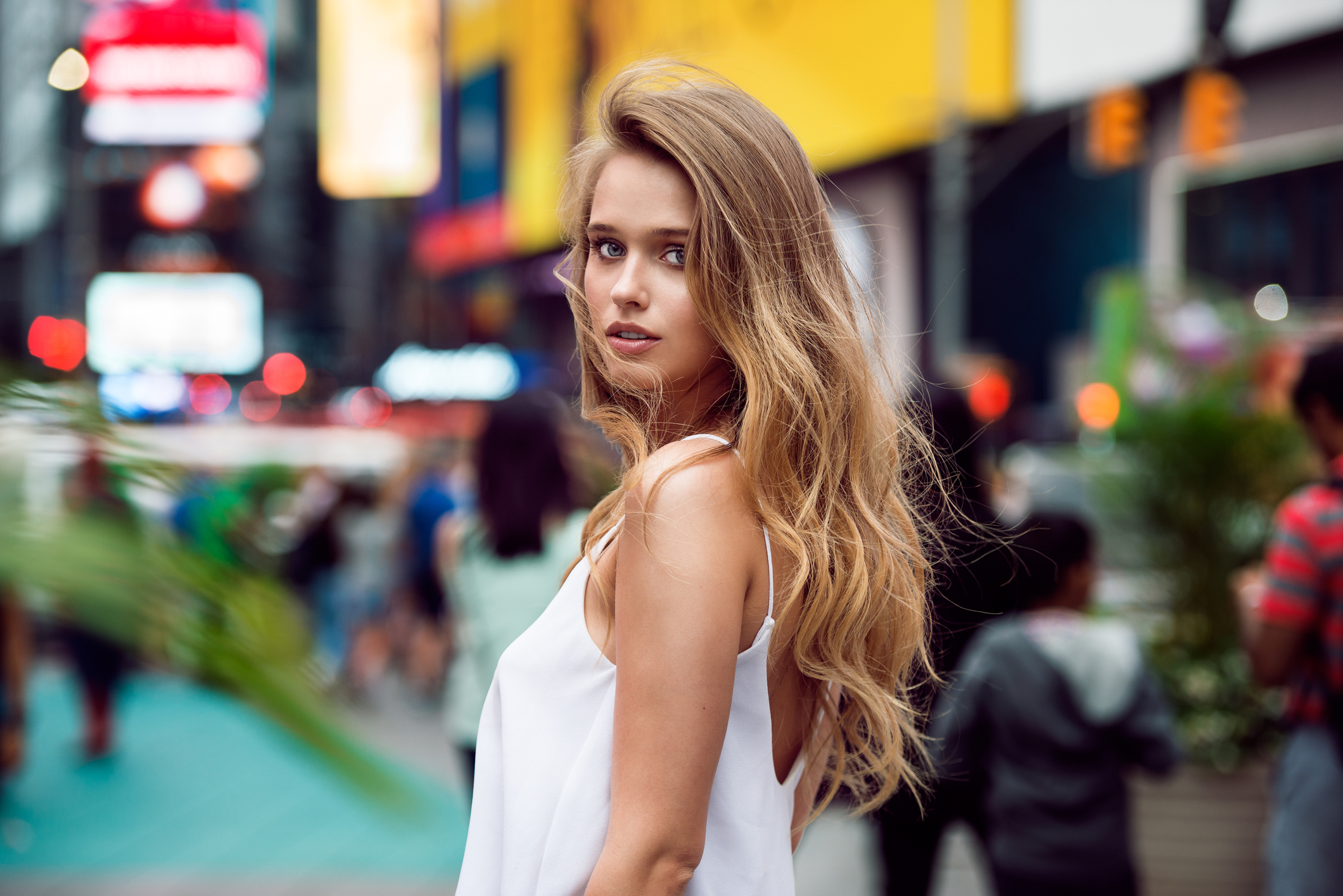 Beautiful blonde sexy tourist girl walking in busy city street