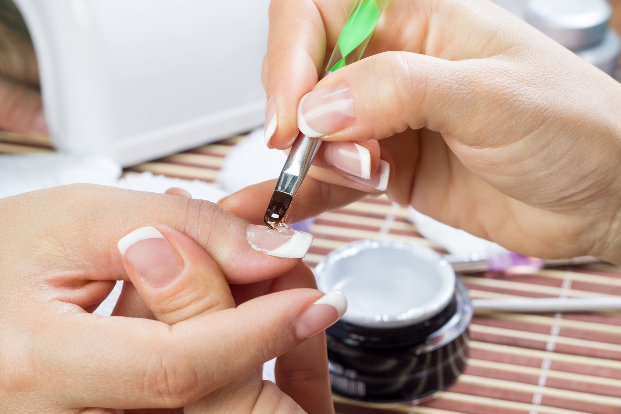 Manicurist doing white French manicure