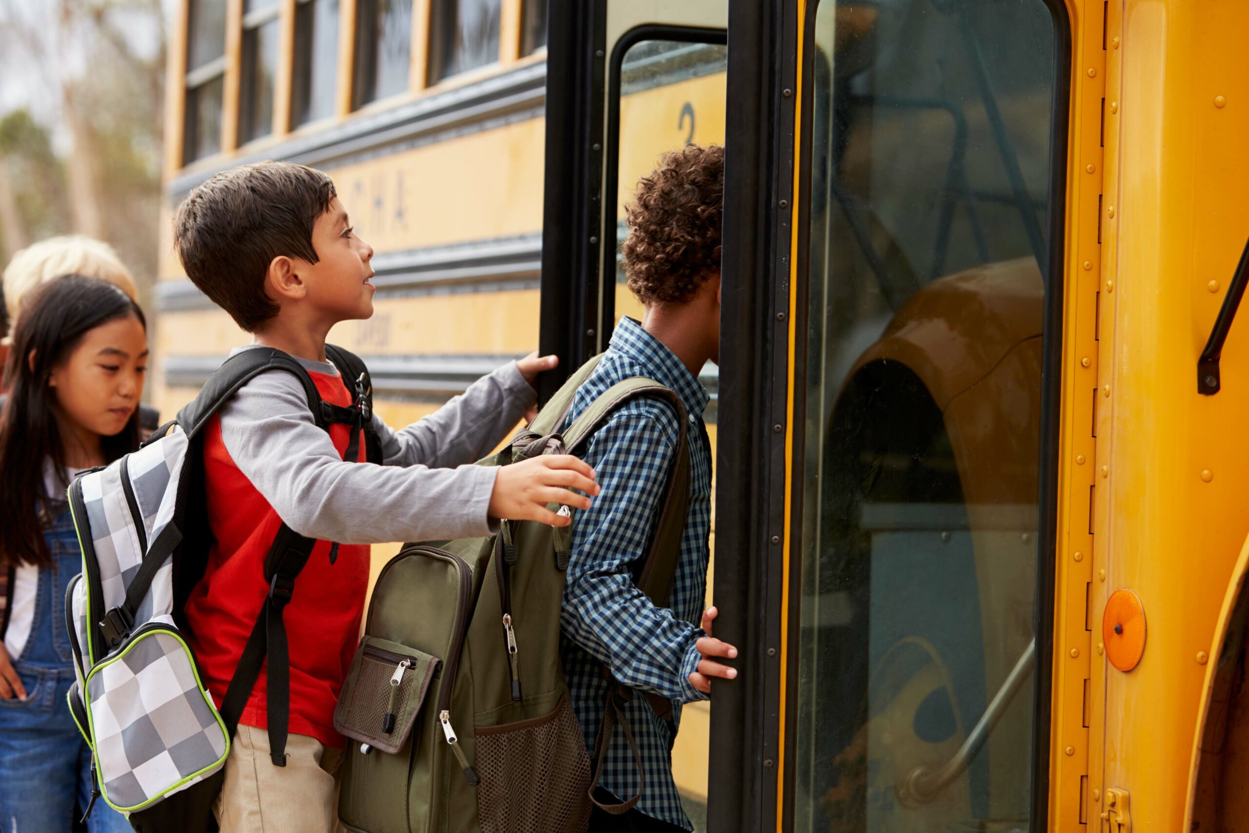 Elementary school kids climbing on to a school bus